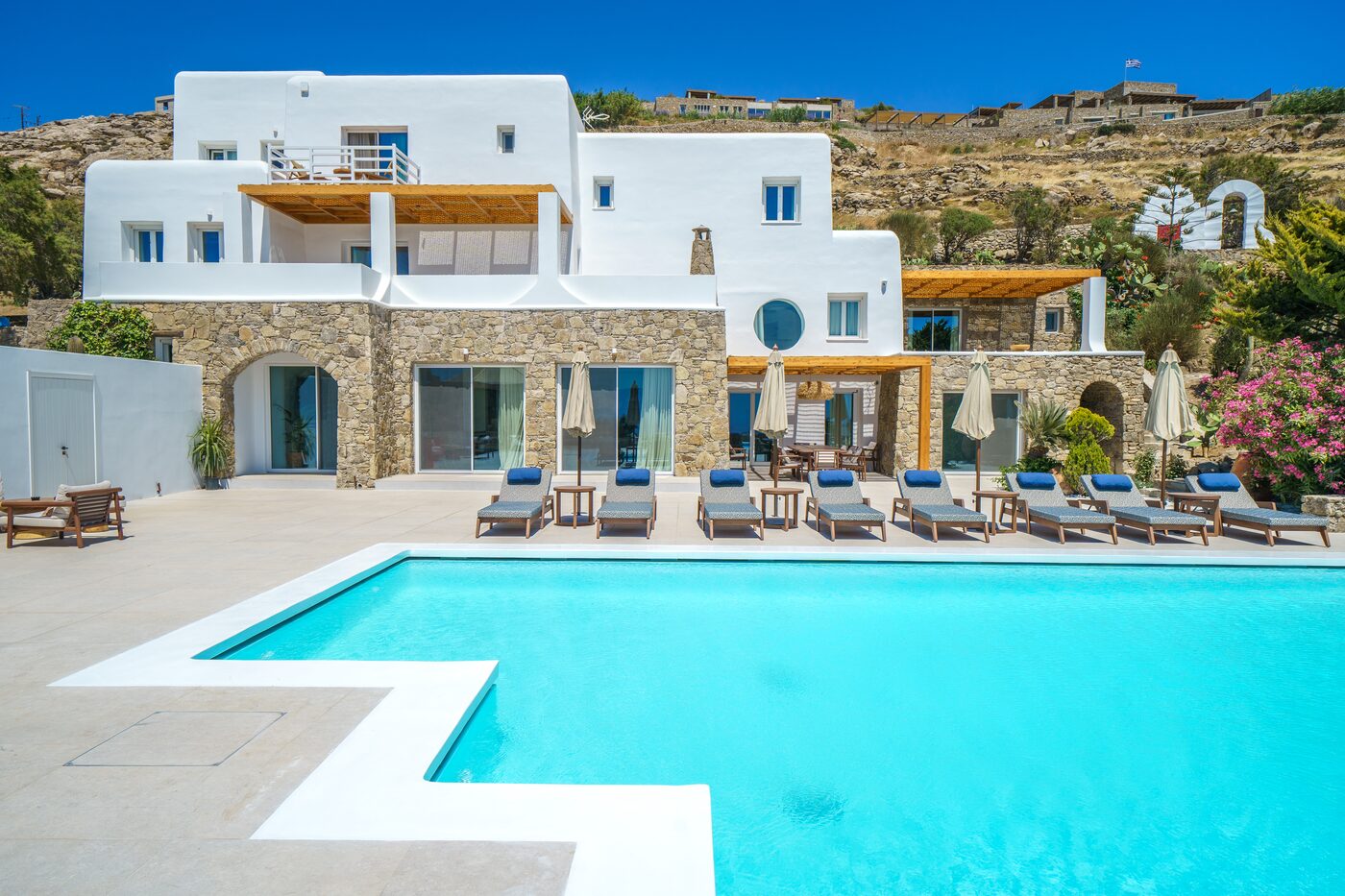 Whitewashed villa facade, pool and bougainvillea at Primadonna, Mykonos