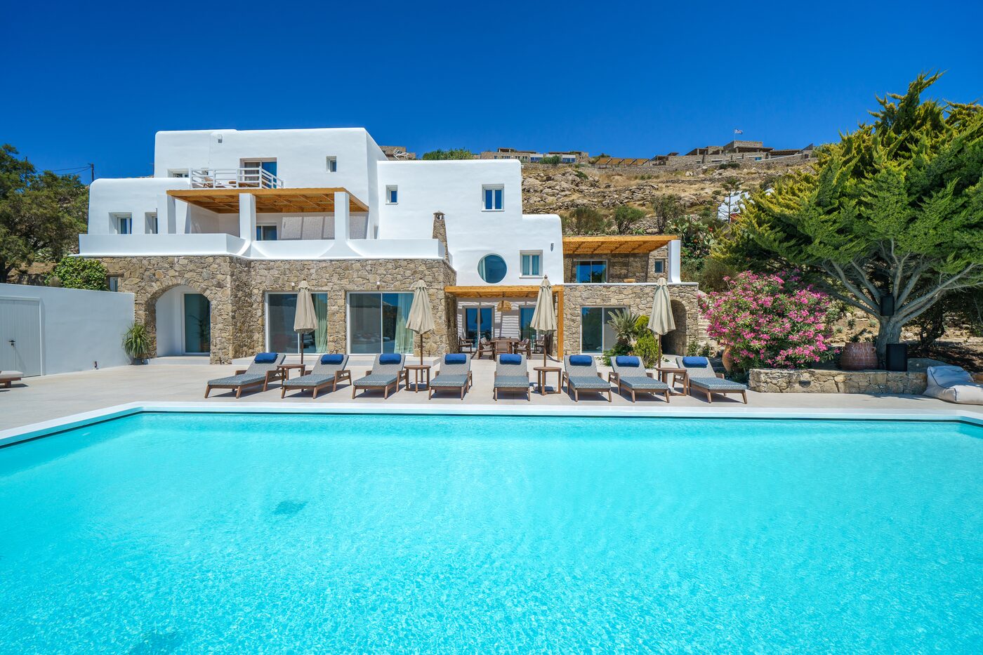 Turquoise pool framed by Cycladic villa architecture at Primadonna