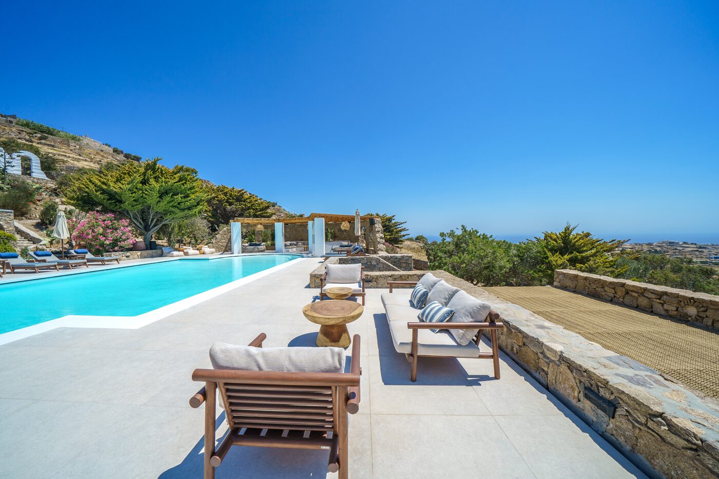 Sun loungers beside the pool with panoramic Aegean sea views