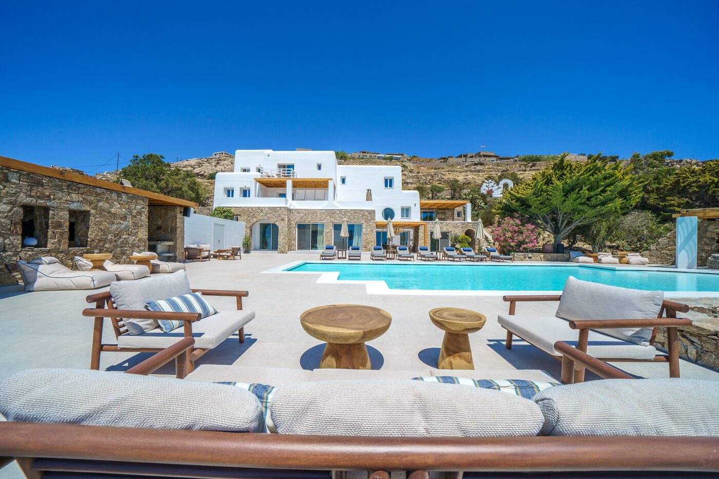 Cushioned outdoor lounge seating beside the pool at Primadonna