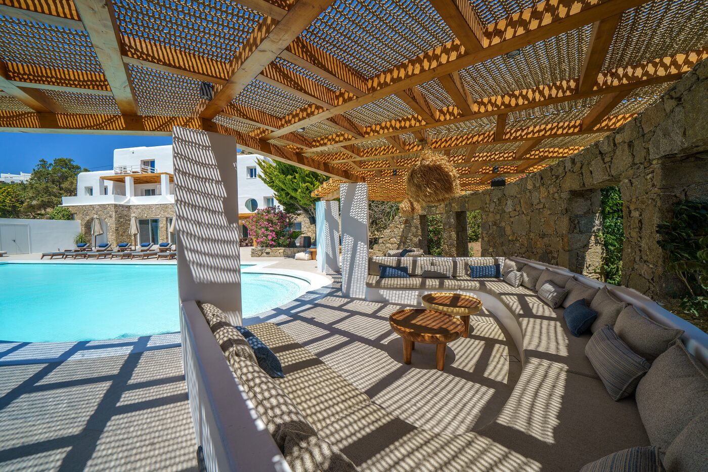 Reed-roofed pergola and outdoor seating overlooking the pool