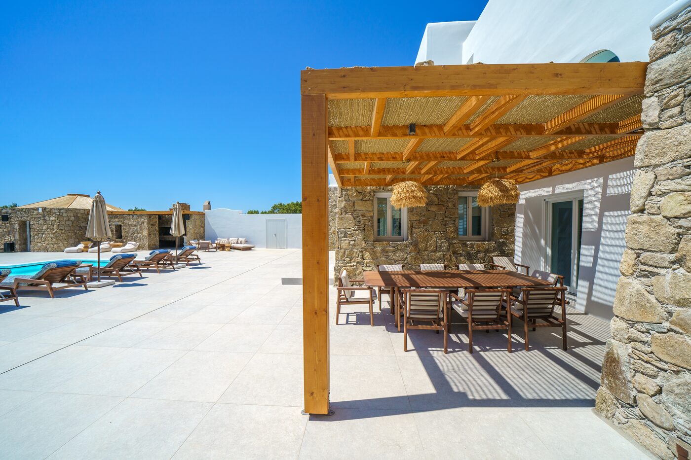Alfresco dining under a timber pergola at a Mykonos villa