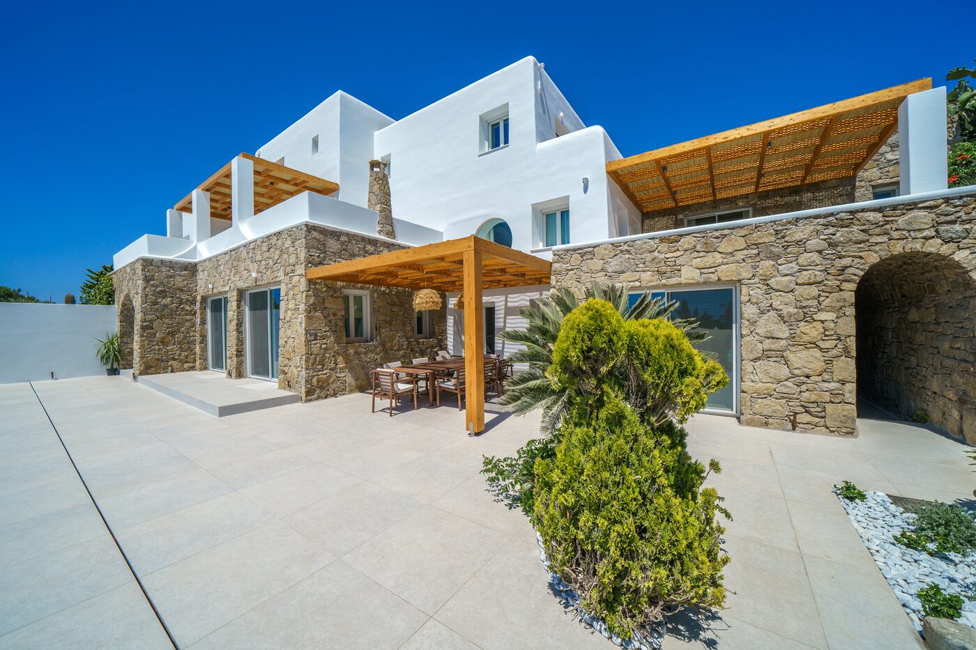 Whitewashed villa architecture with pergola and Mediterranean greenery
