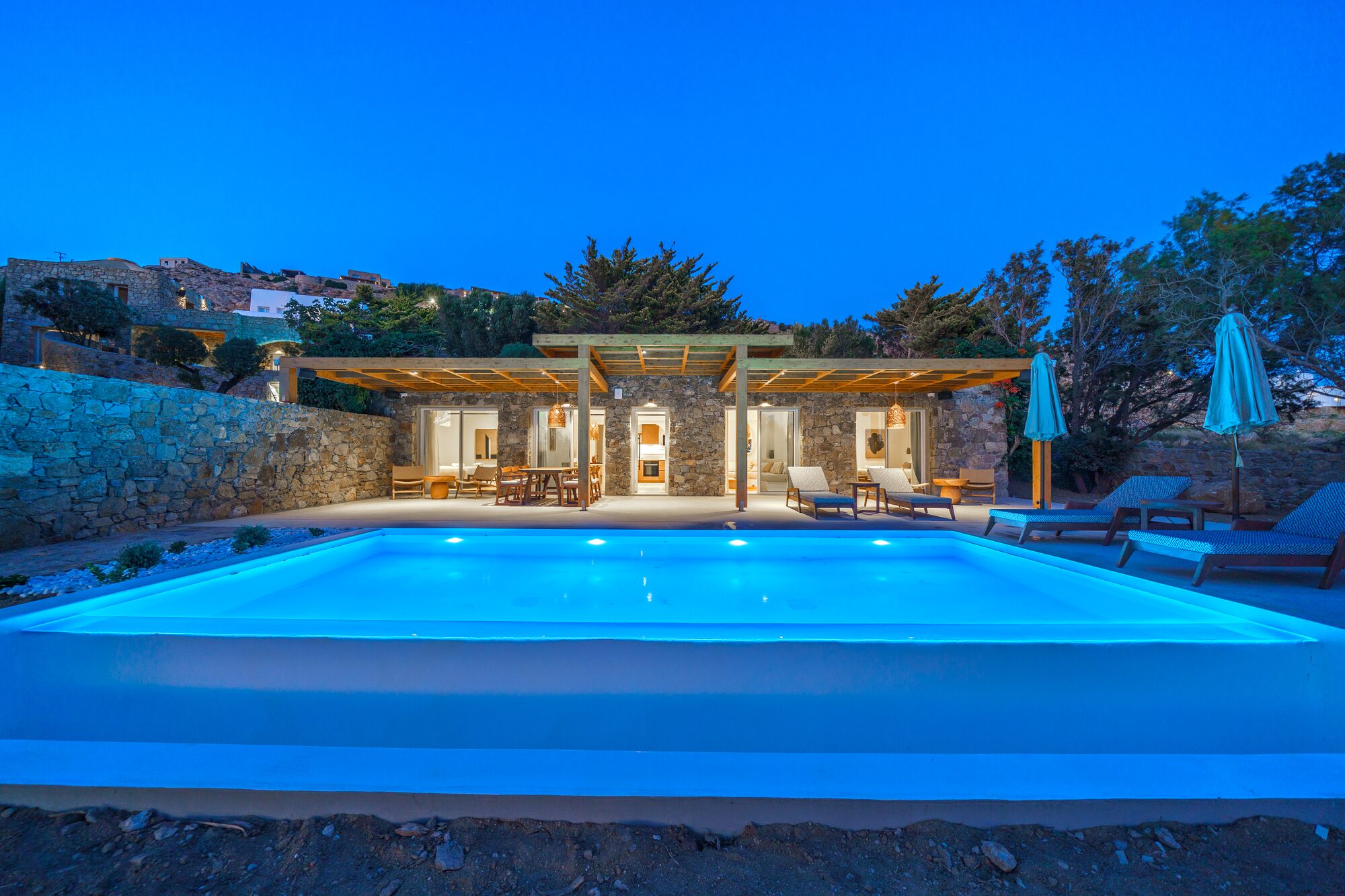 Infinity pool and villa glowing at blue hour, Primadonna, Mykonos