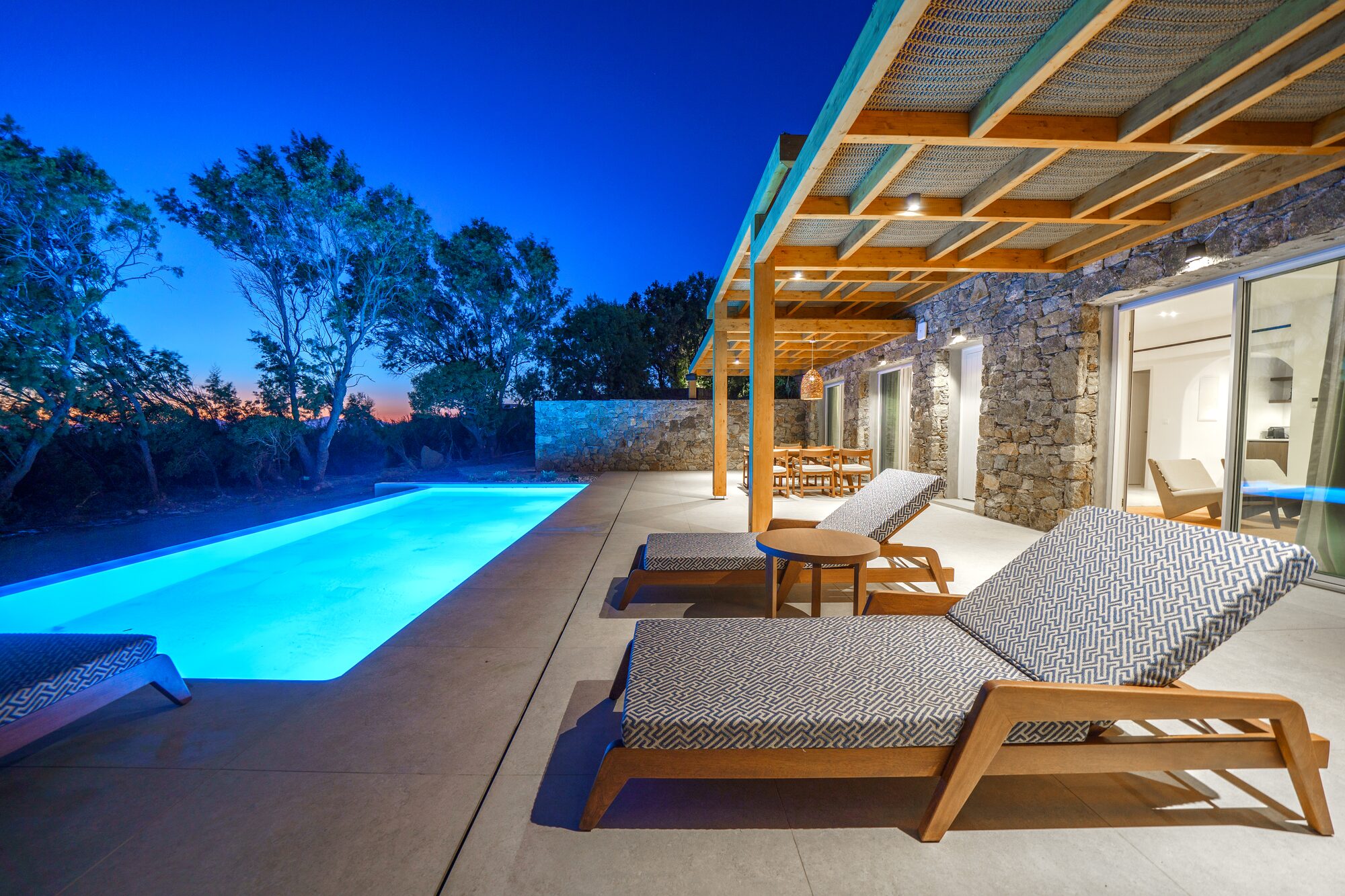 Sun loungers beside the pool under a pergola at twilight, Mykonos