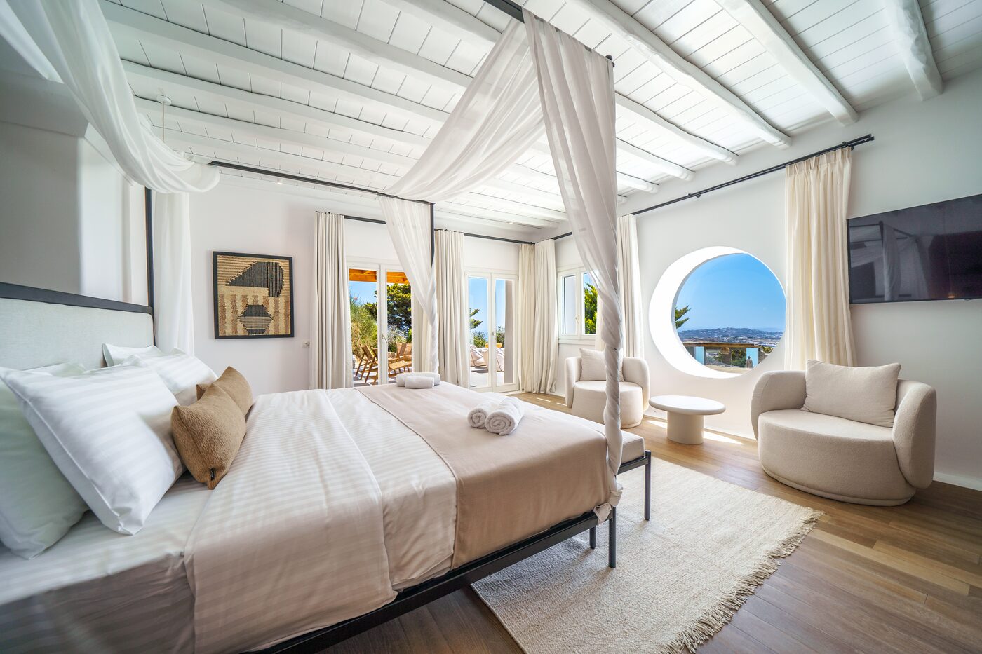 Villa Primadonna master suite with a four-poster canopy bed and Aegean sea view