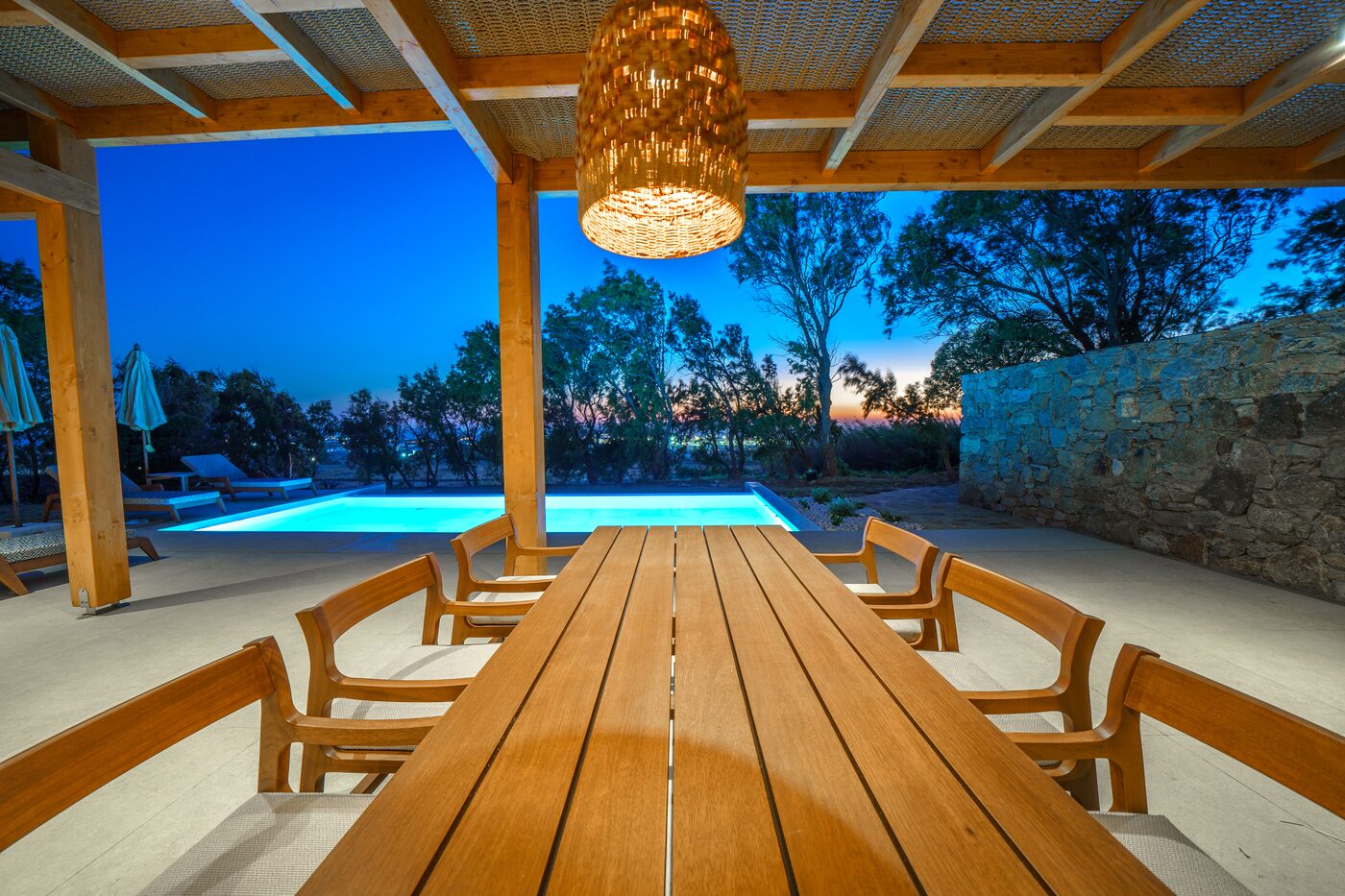 Pergola-covered dining terrace beside the pool at twilight, Primadonna
