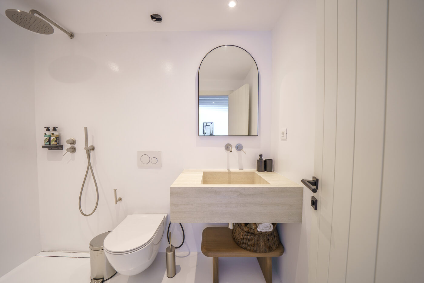 Villa Afrodite ensuite bathroom with a carved stone basin, arched mirror and walk-in shower
