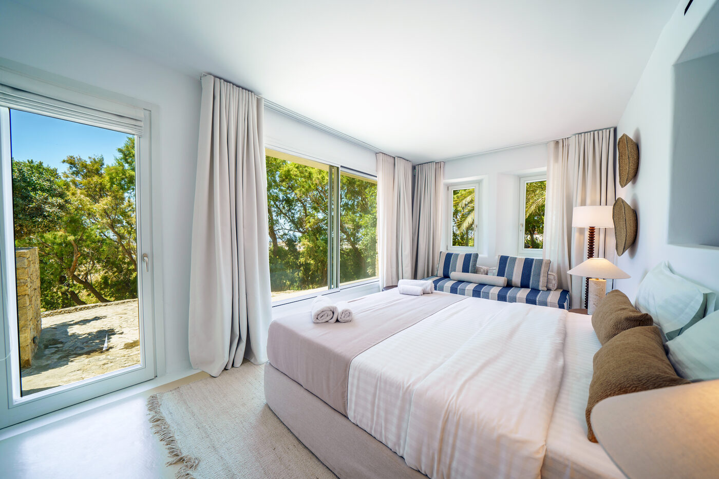 Villa Afrodite twin bedroom with a striped daybed and panoramic sea-view windows