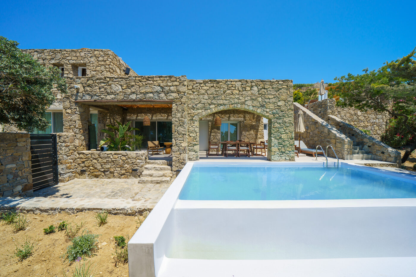 Villa Afrodite natural stone exterior and cascade pool on the Mykonian hillside
