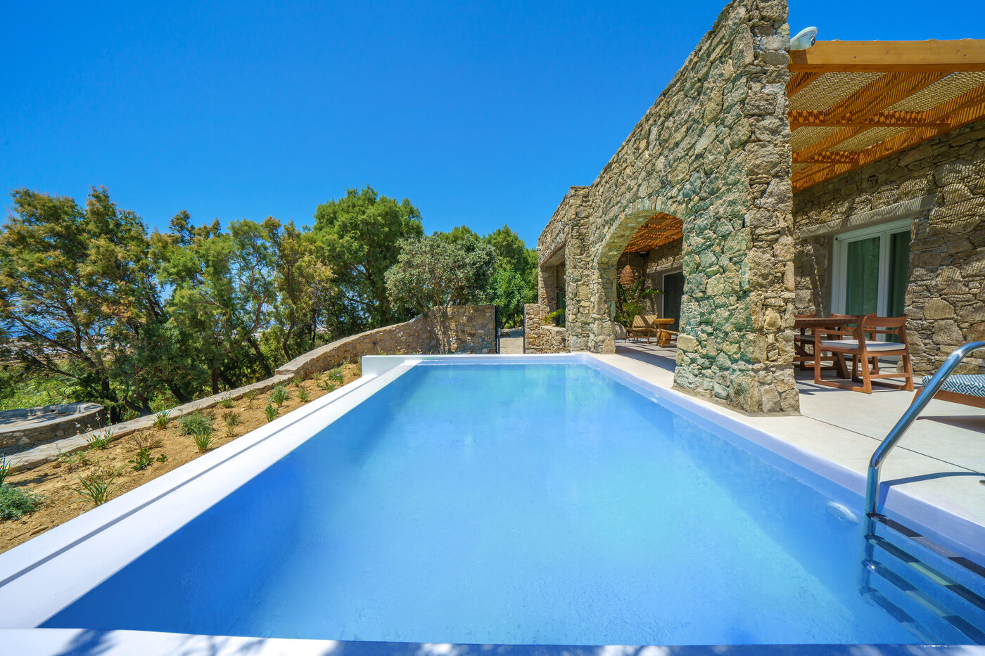 Villa Afrodite cascade pool and stone-paved sun terrace with loungers