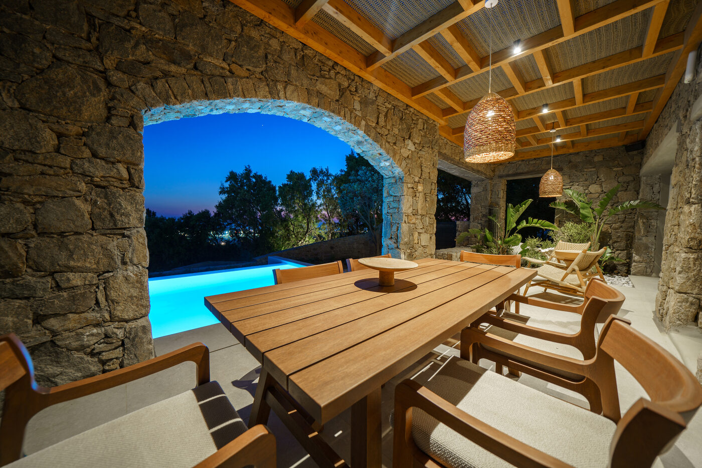 Villa Afrodite pergola dining terrace beside the pool at dusk