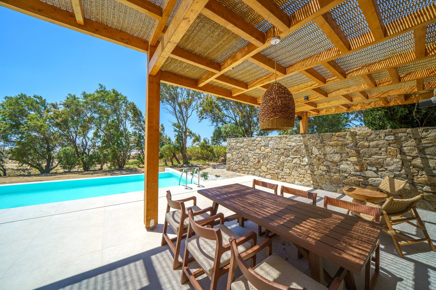 Villa Catherine alfresco dining table under a timber pergola beside the pool