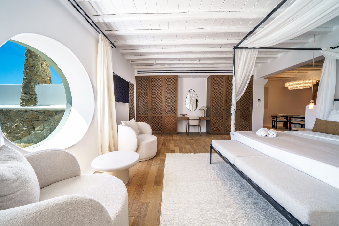 Villa Primadonna master suite with a four-poster canopy bed and round sea-view window
